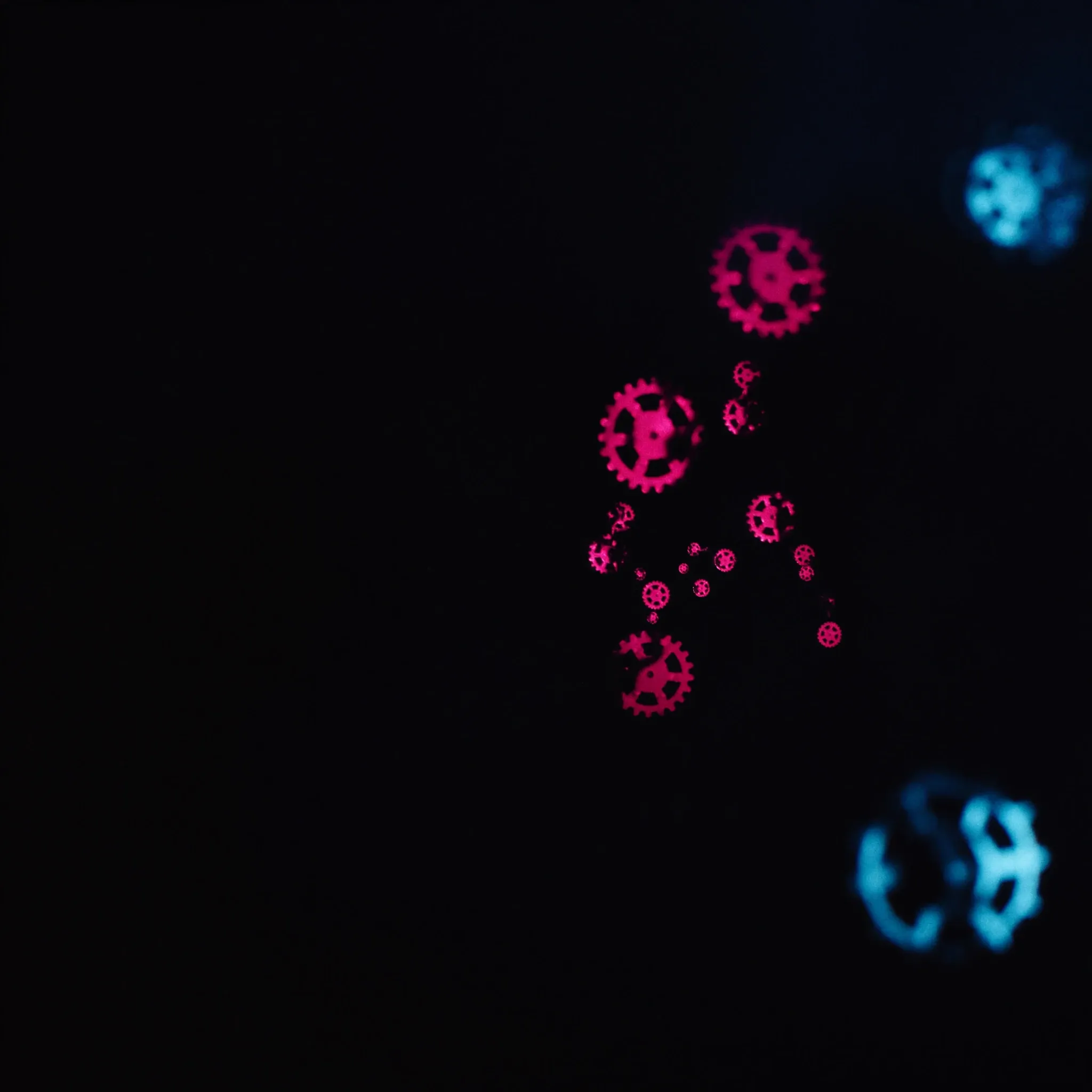 Gears made of light turning together smoothly in darkness