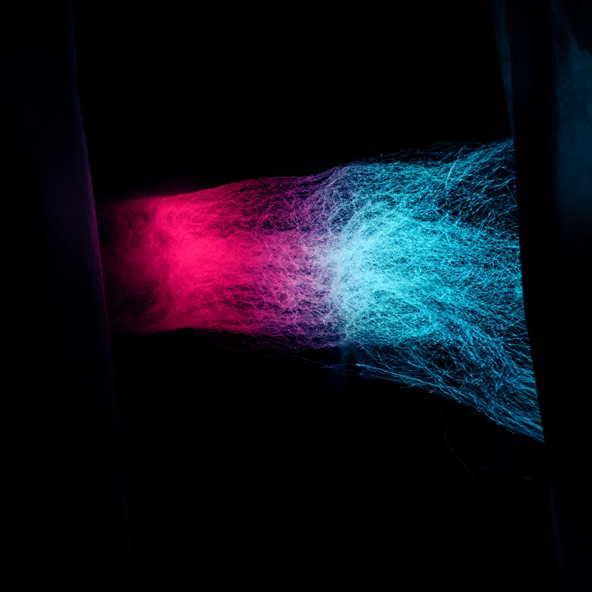 Fine threads of light woven on a loom-like frame, cyan and pink