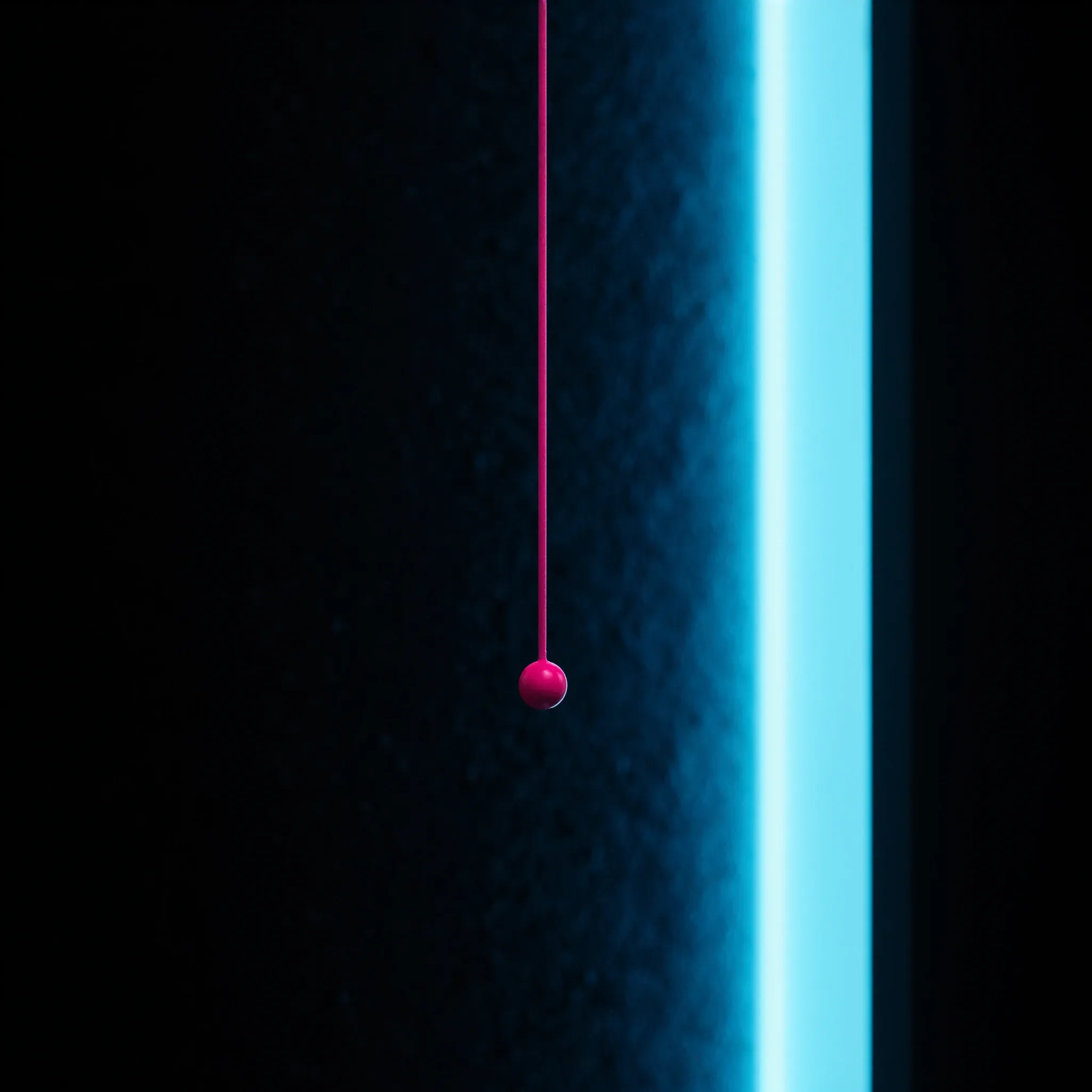 A plumb line hanging perfectly still in front of a dark textured wall, lit by a thin cyan beam