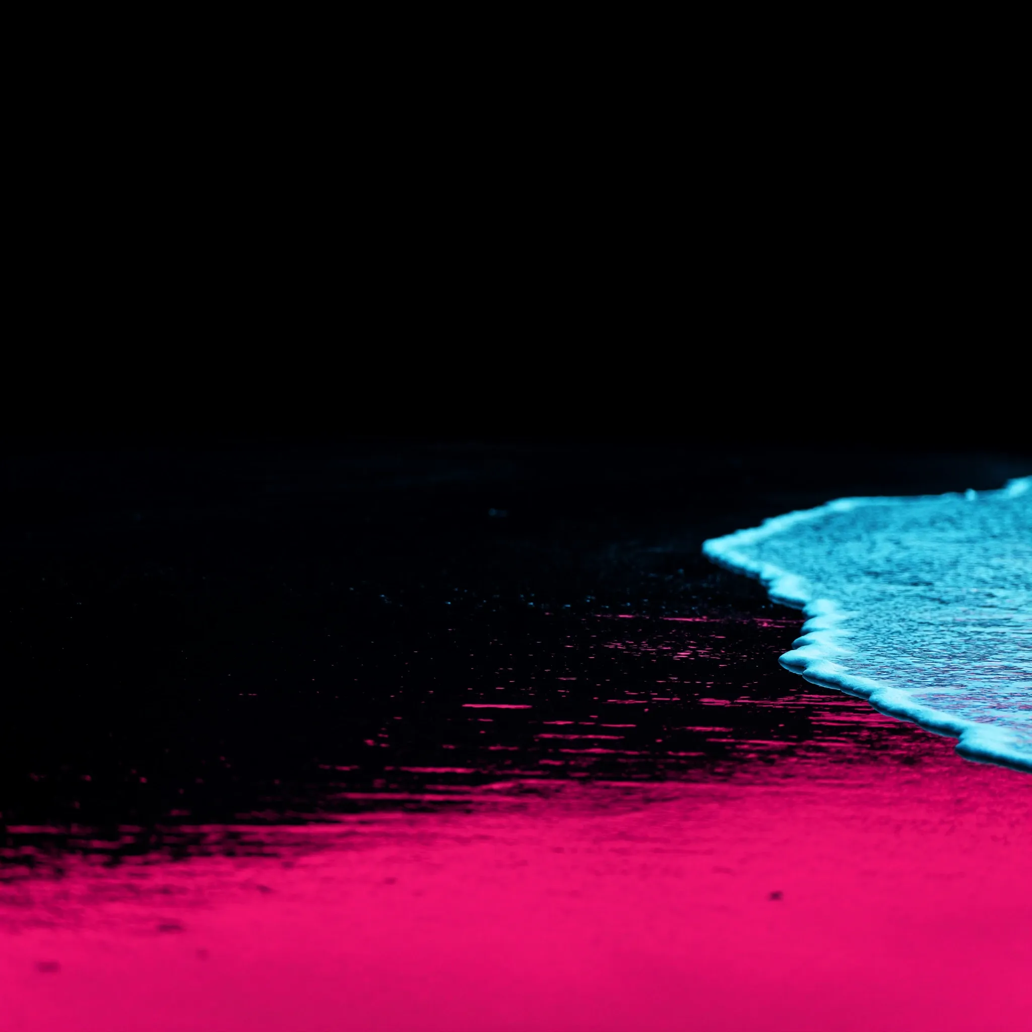 Wet sand at the waterline reflecting a pink and blue sky, the thin edge of one wave, calm