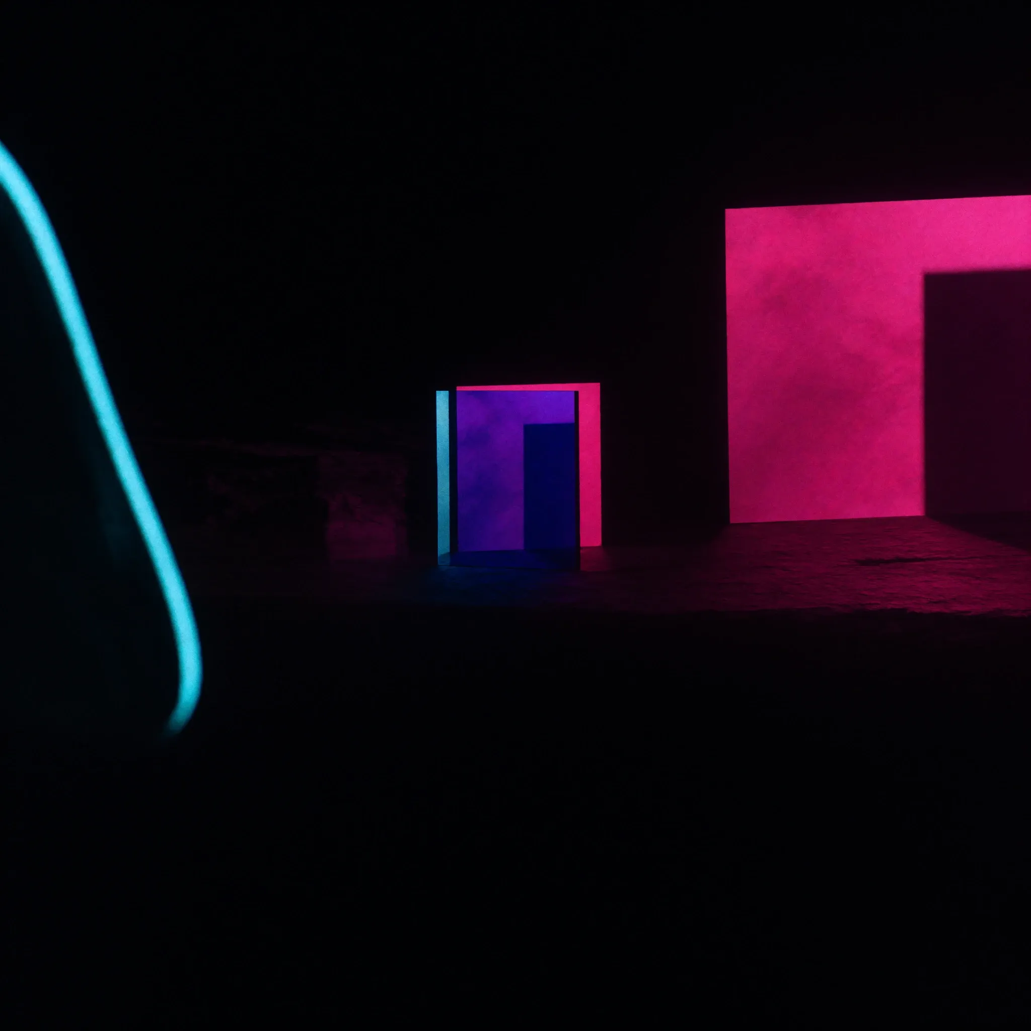 Layers of coloured glass casting overlapping pink and blue shadows across dark stone