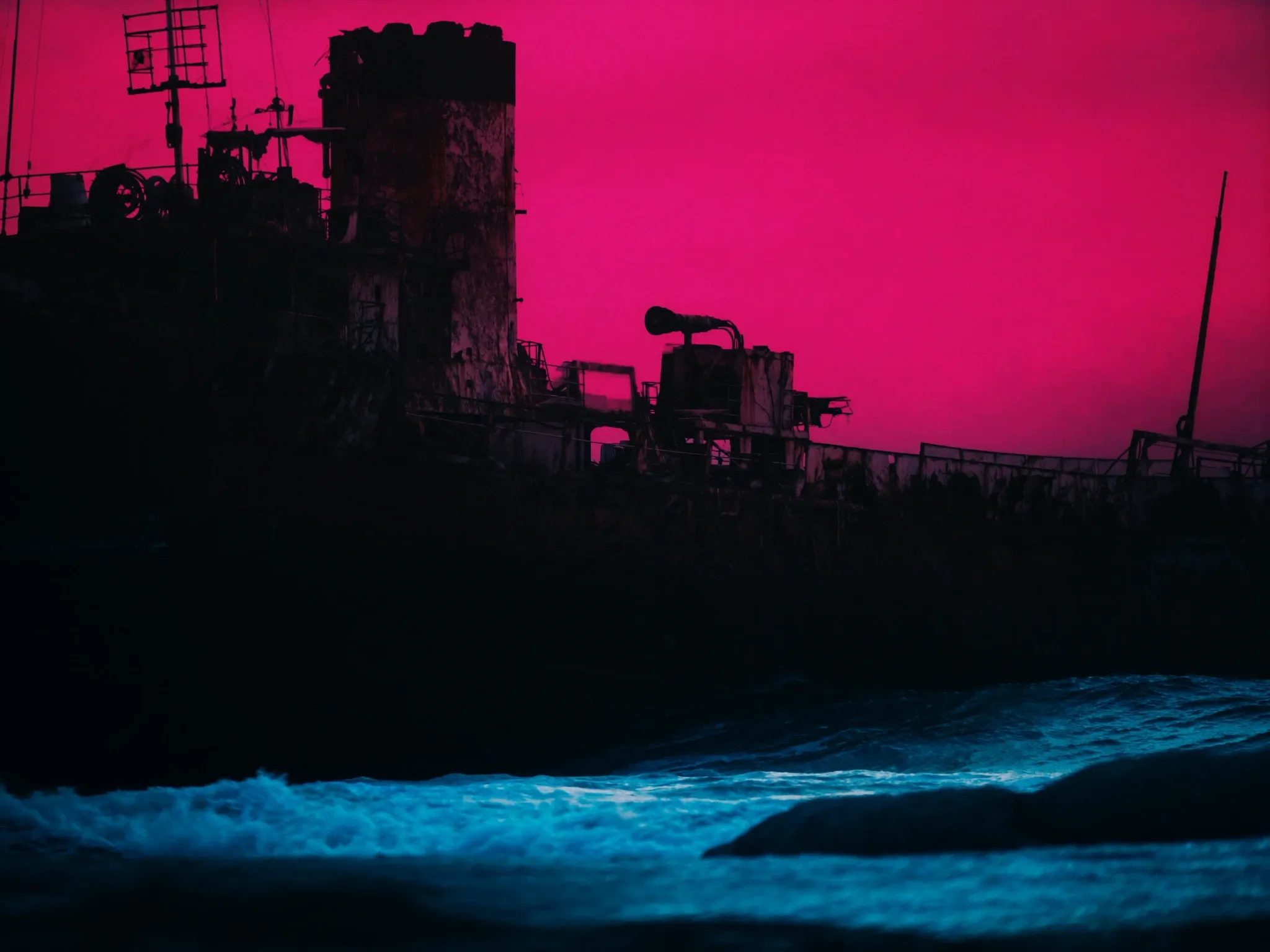 The rusted hull of an old shipwreck on a Cape Town beach at dusk, waves washing around it, a pink sky