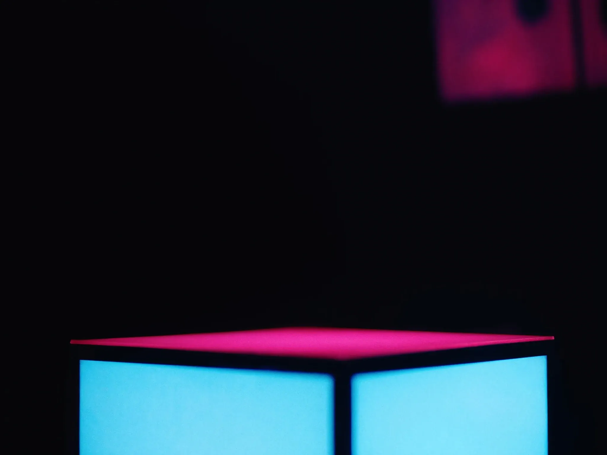An empty, perfectly lit display plinth in a dark room