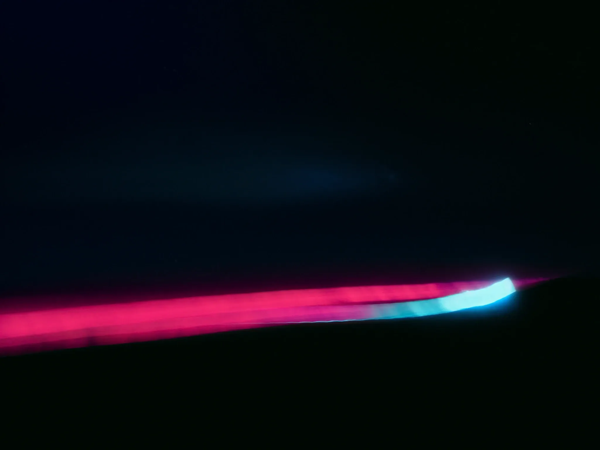 A long-exposure ribbon of light along the N1 highway at night, crossing the dark highveld toward Johannesburg's glow