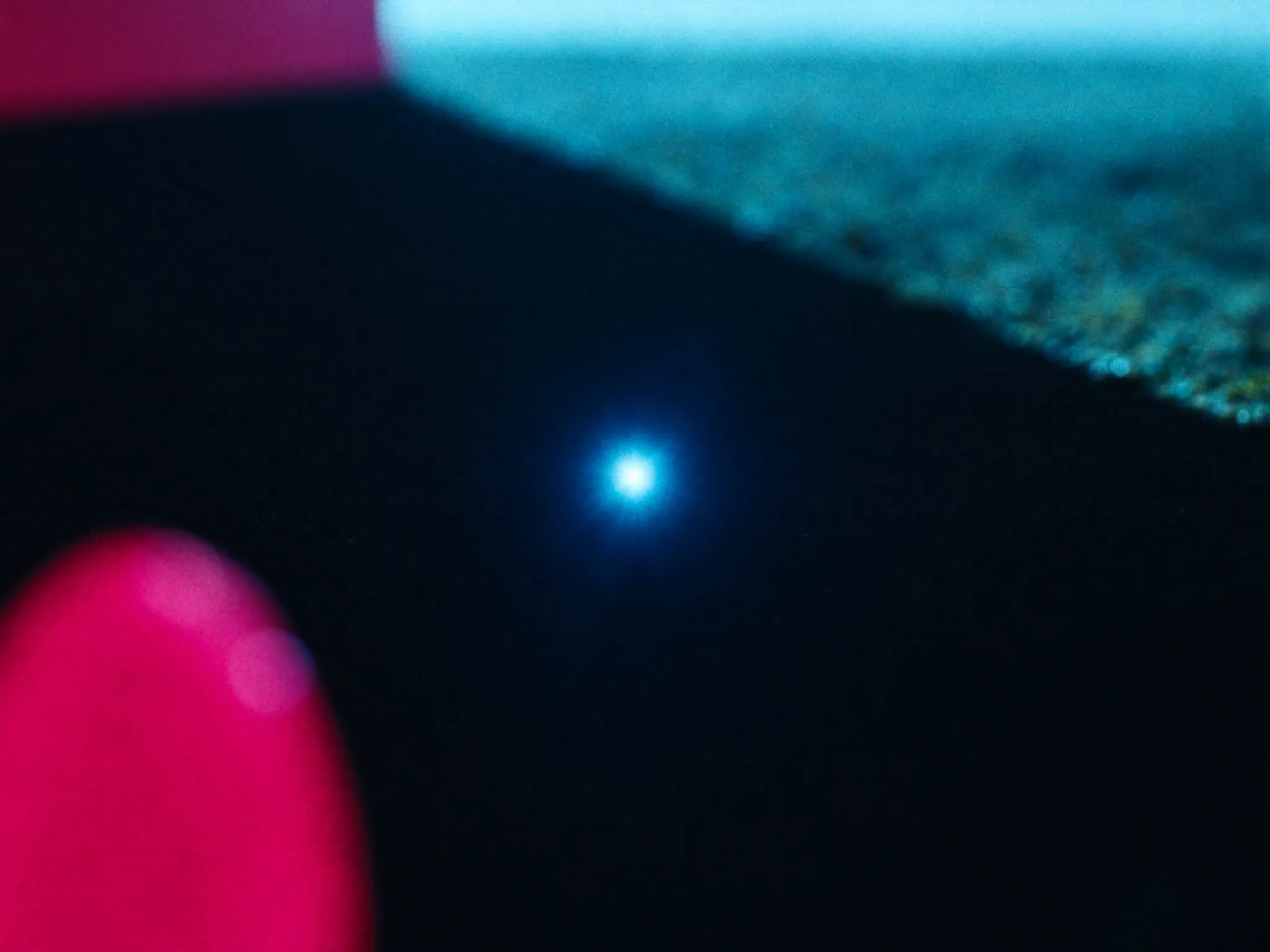 Light focused through a lens into one precise bright point on dark ground